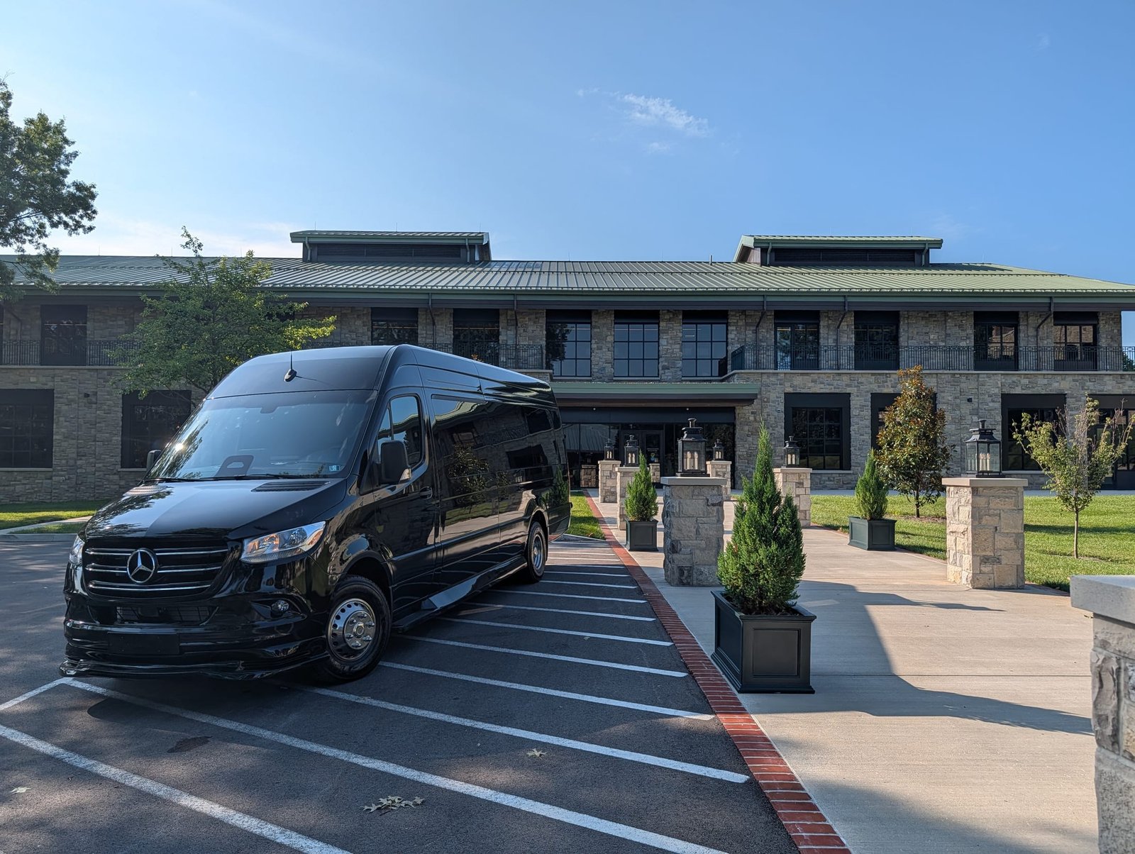 Black Mercedes Sprinter van outside a stone resort