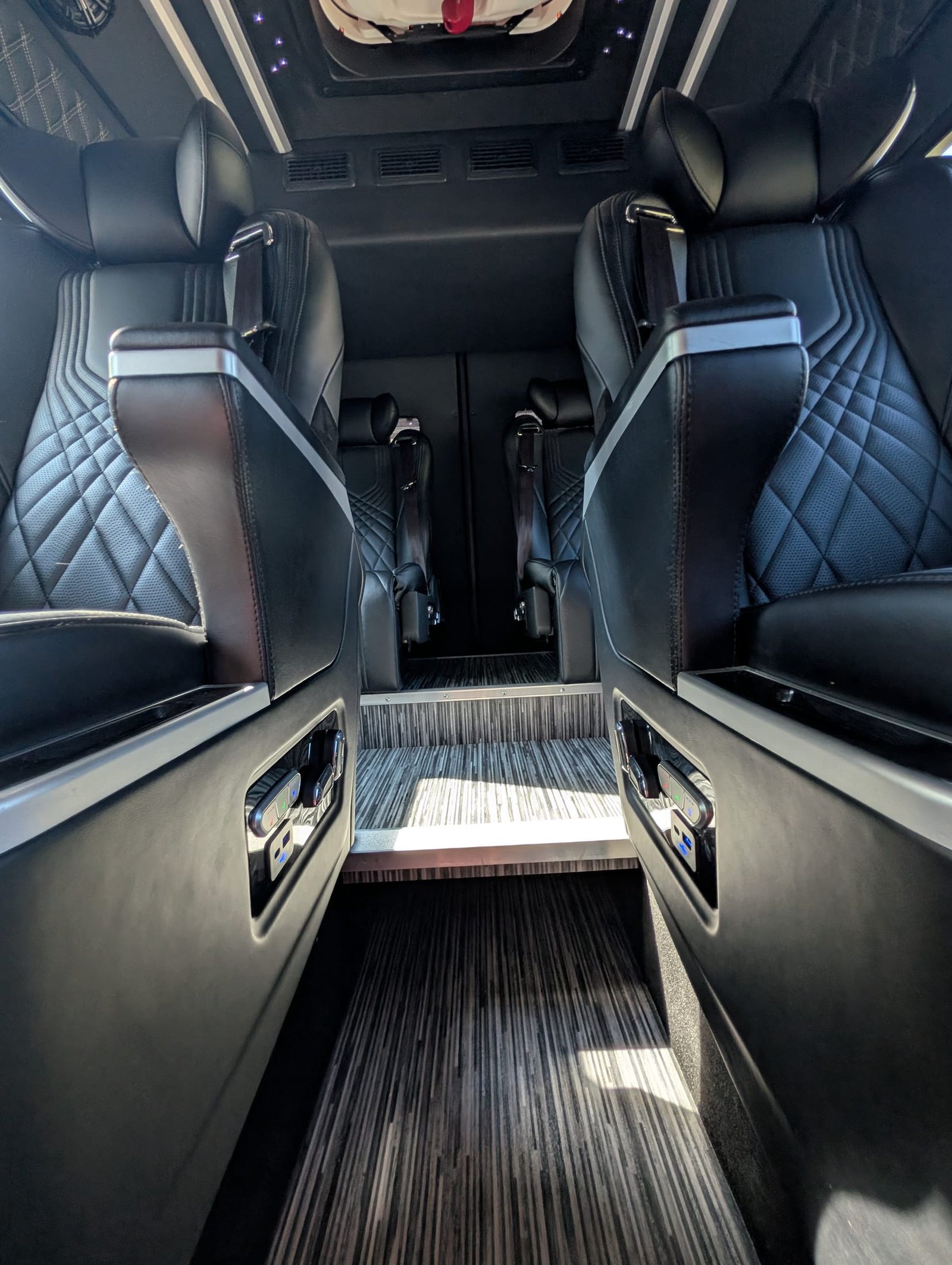 Aisle between captain's chairs with wood-look flooring